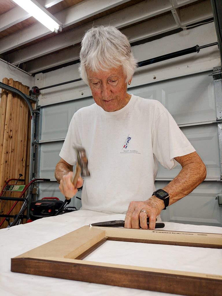 Nancy pounding V-nails into frame.